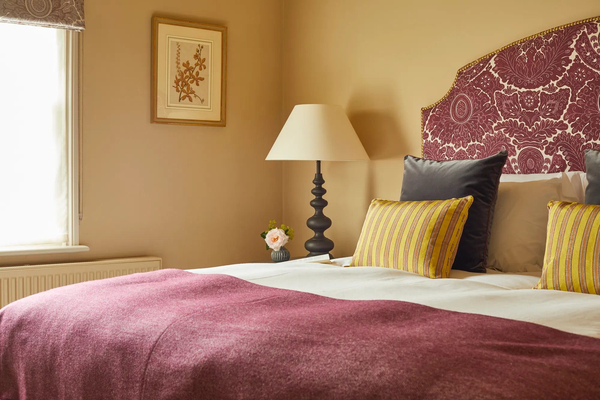 Vale: a maroon leaf-patterned headboard and plum throw