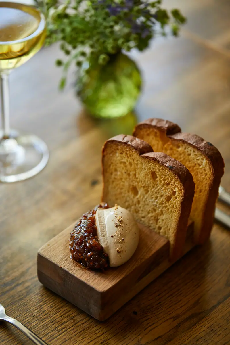 Smooth parfait with chutney and thick slices of toasted brioche on a wooden board